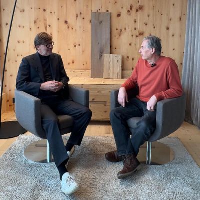 Holzgespräch bei Stark AG Zwei Männer im Gespräch in einem modernen Raum mit Holzwandverkleidung.