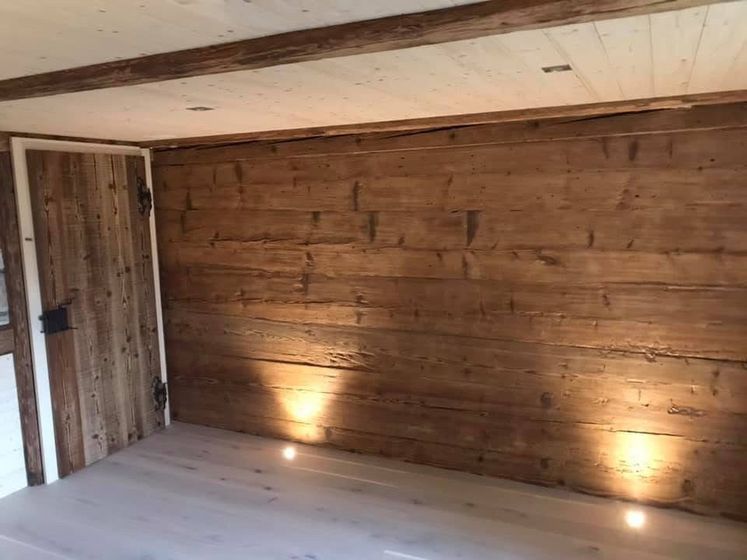 Gemütlicher Raum mit Holzvertäfelung und moderner Beleuchtung.