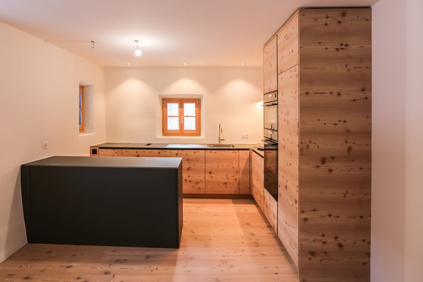 Moderne Küche mit Holzelementen und minimalistischer Ausstattung.