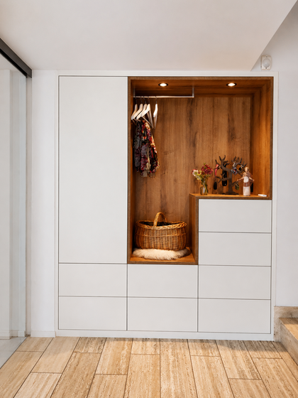 Moderner Einbauschrank mit Holzverkleidung und dekorativen Elementen.
