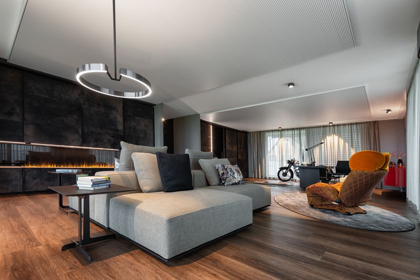 Modernes Wohnzimmer mit stilvollen Möbeln, Holzboden und dekorativem Kamin.