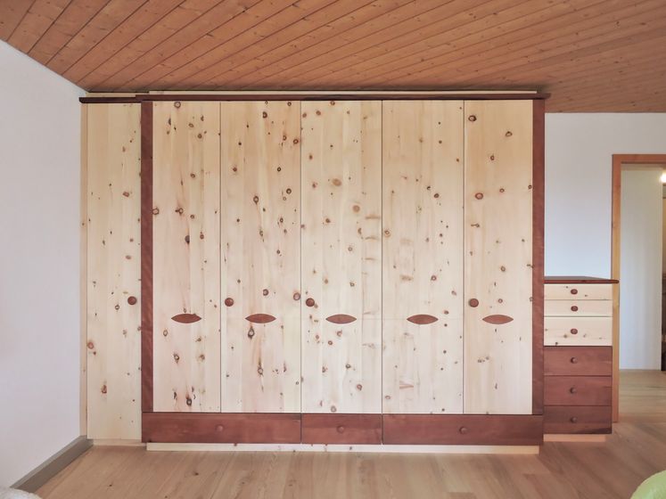 Holzschrank mit modernem Design in einem Raum mit Holzdecke.