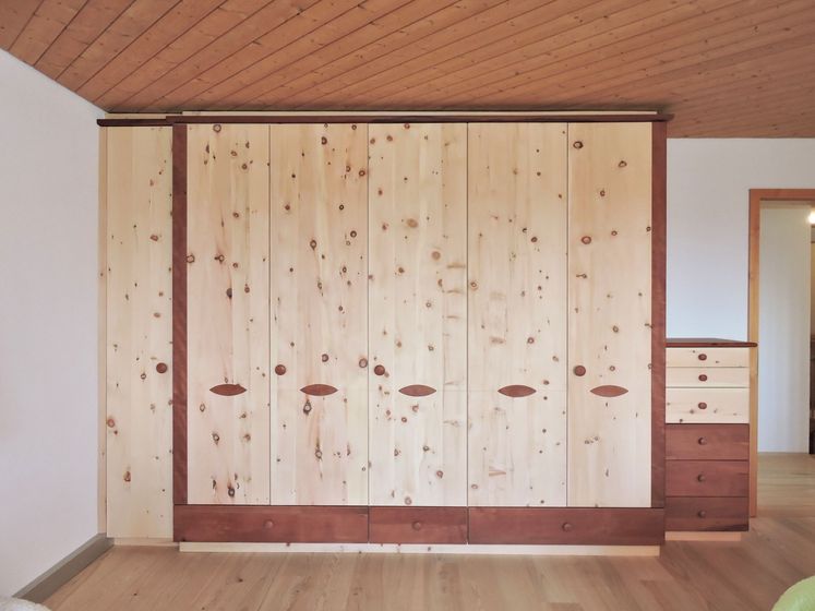Holzschrank mit modernem Design in einem Raum mit Holzdecke.