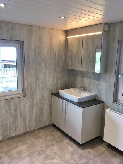 Modernes Badezimmer mit Holzoptik-Wandverkleidung und Waschbecken.