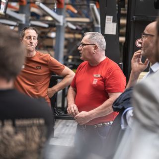 Mitarbeiter der Stark AG diskutieren in einer Lagerhalle.