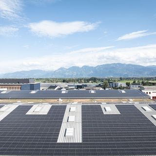 Dächer der Stark AG mit Solaranlagen vor einer Berglandschaft.