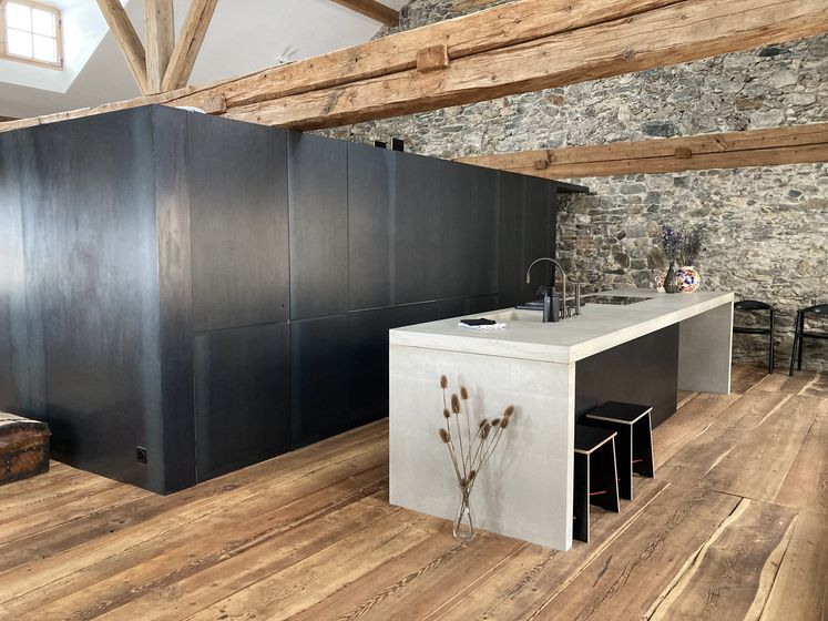 Moderne Küche mit Holzelementen und Steinwand.