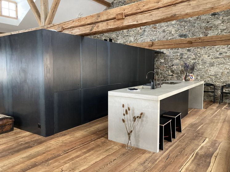 Moderne Küche mit Holzelementen und Steinwand.
