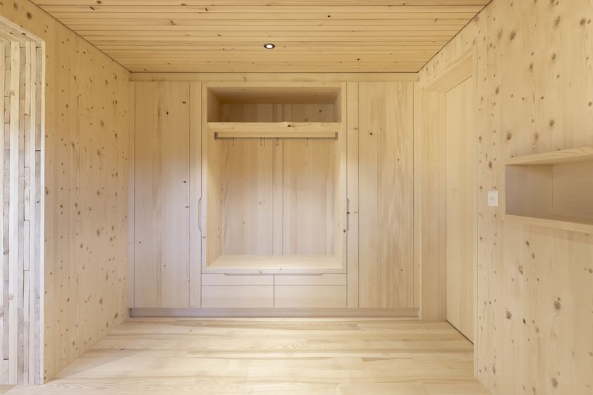 Heller Raum mit Holzverkleidung und integriertem Schrank.