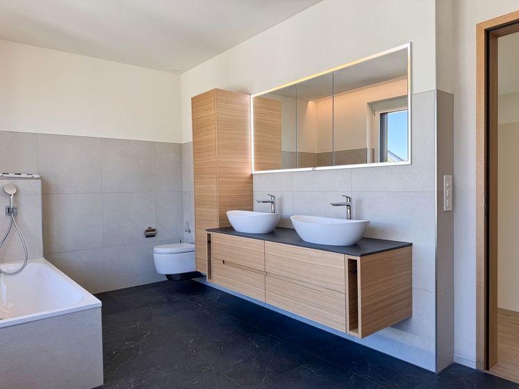 Modernes Badezimmer mit freistehenden Waschbecken und Holzverkleidung.