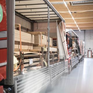 Holzwerkstoffe in offenen LKWs eines Holzhändlers gelagert.