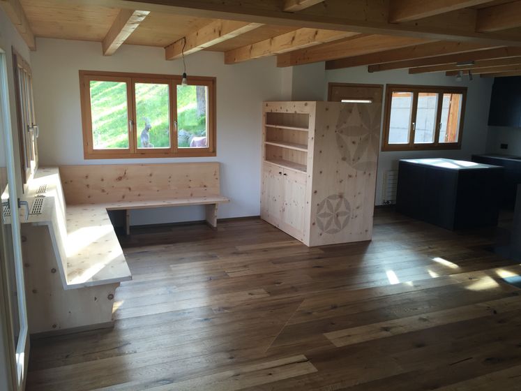 Gemütlicher Innenraum mit Holzverkleidungen und massiven Holzmöbeln.