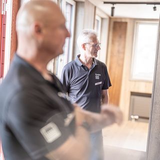 Mitarbeiter der Stark AG beraten Kunden vor einer Holzausstellung.