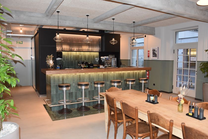 Moderne Bar mit Holztheke und Sitzgelegenheit in einem stilvollen Raum.
