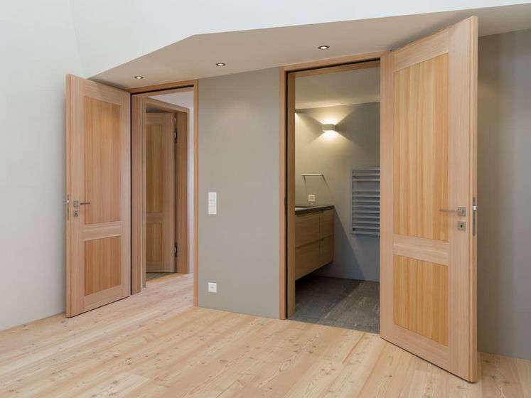 Moderner Innenraum mit Holztüren und Parkettboden.