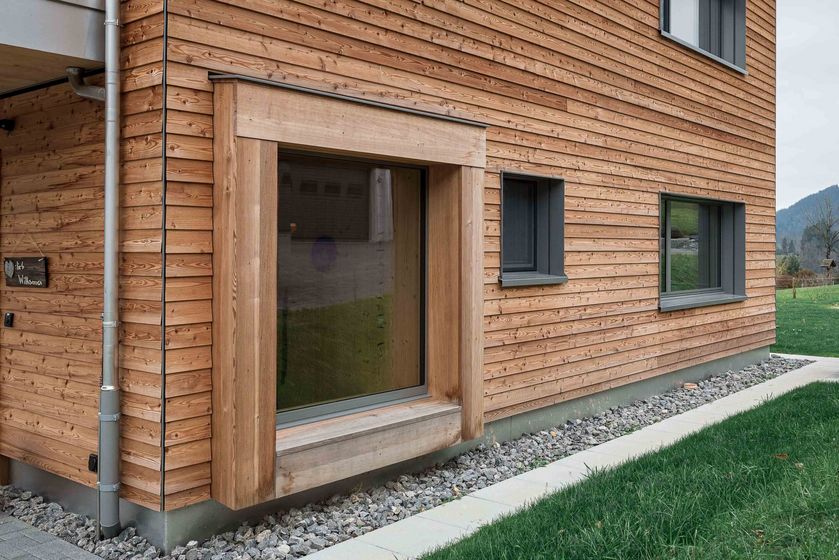 Modernes Gebäude mit Holzverkleidung und grossen Fenstern.