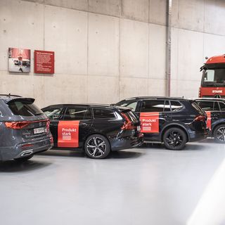 Firmenfahrzeuge und Lkw der Stark AG in einer Halle geparkt.