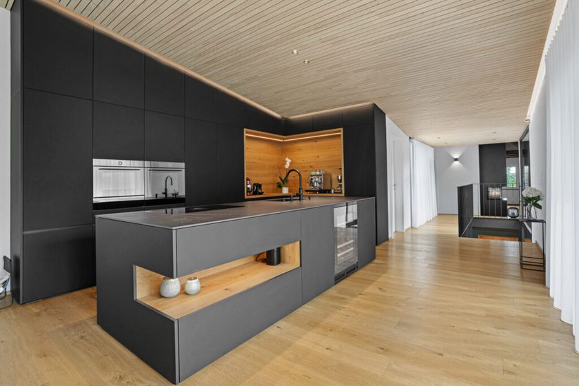 Moderne Küche mit eleganten Holzelementen und dunkler Einrichtung.
