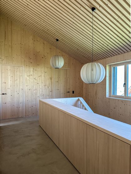 Modernes Interieur mit Holzvertäfelung und minimalistischen Leuchten.