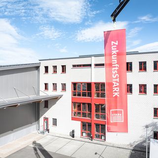Ein rotes Banner mit der Aufschrift 'ZukunftsSTARK' hängt an einem Gebäude der Stark AG Altstätten.