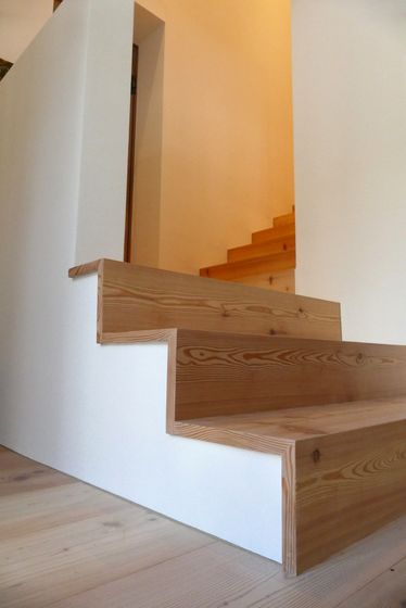 Moderne Holztreppe mit klaren Linien in einem Innenraum.
