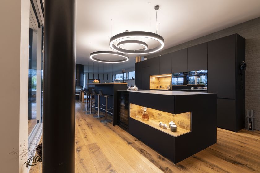 Moderne Küche mit Holzfussboden und stilvoller Beleuchtung.
