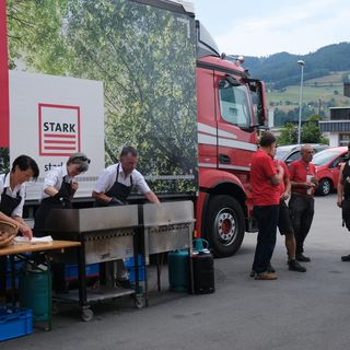 Ein Team der Stark AG bei einem Firmenevent neben einem LKW.