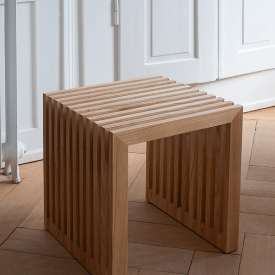Moderner Holzstuhl mit geripptem Design in einem elegant eingerichteten Raum.