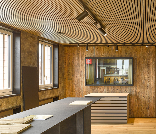 Moderne Ausstellungsfläche mit Holzverkleidung und Mustertischen bei Stark AG Altstätten.