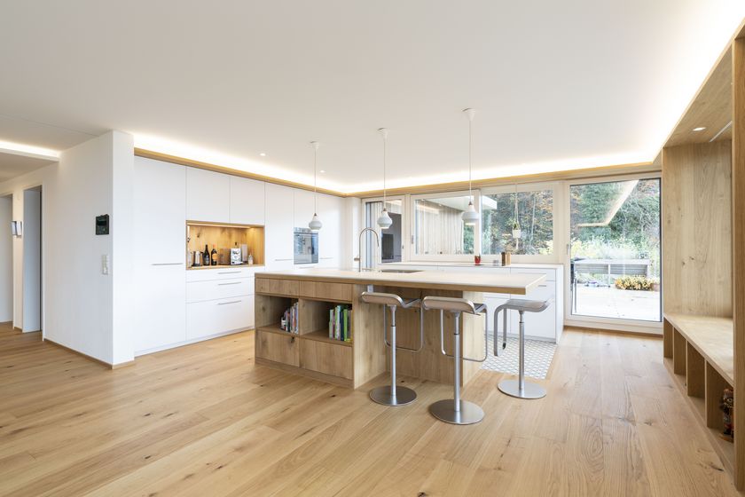 Moderne Küche mit Holzakzenten und Insel in einem Wohnraum.