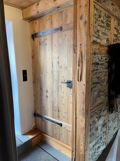 Rustikale Holztür mit Steinwand.