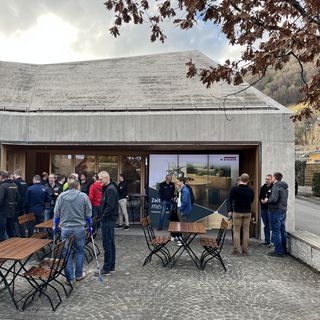 Gruppe von Menschen bei einem Outdoor-Event vor einem modernen Gebäude.