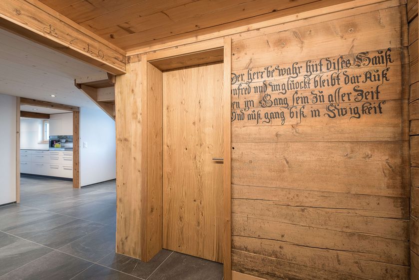 Moderner Innenraum mit Holzwand und graviertem Schriftzug.