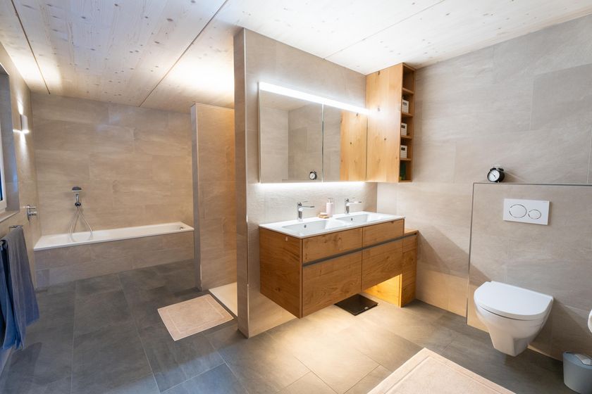 Modernes Badezimmer mit Holzvertäfelung und Doppelwaschbecken.