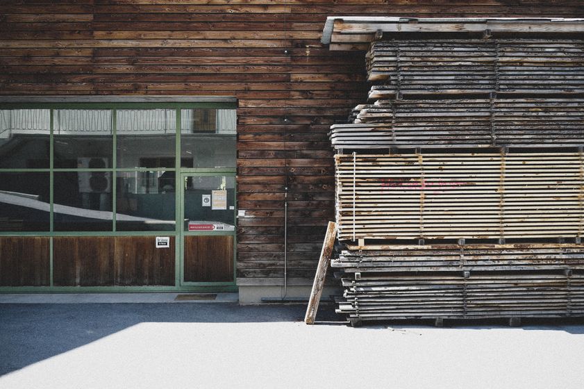 Gestapelte Holzbretter vor einem Holzgebäude der Stark AG in Altstätten.
