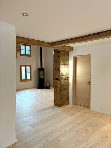 Moderner Innenraum mit Holzböden und rustikalen Holzbalken.