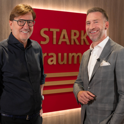 Stark AG Führung Zwei Männer vor dem Stark AG Logo.