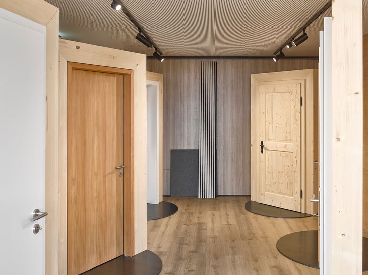 Innenausstellung von Holztüren und Akustik-Wandbelägen in einem Showroom.