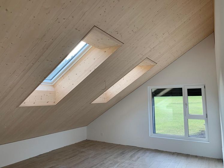 Modernes Dachgeschoss mit Holzverkleidung und Dachfenstern.