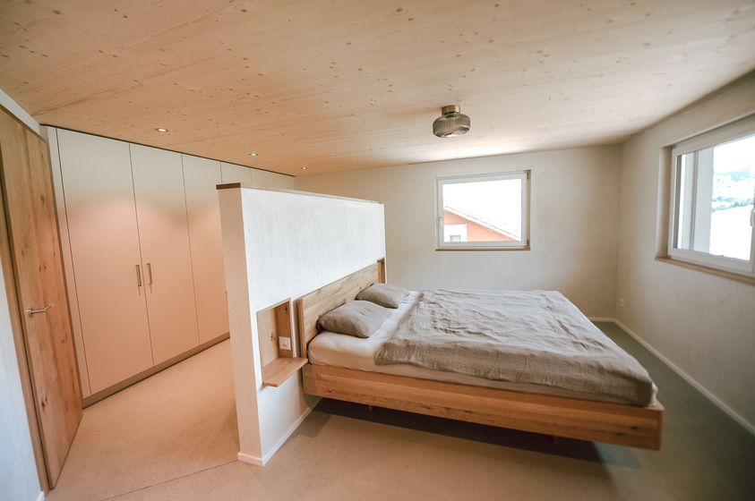 Modernes Schlafzimmer mit Holzdesign und grossem Fenster.
