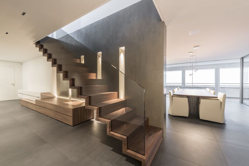 Modernes Interieur mit eleganter Holztreppe und Esstisch.