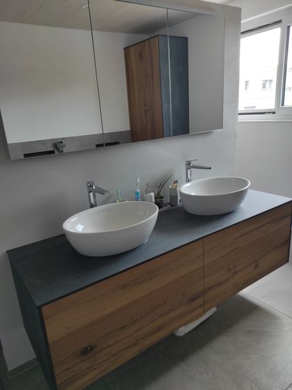 Modernes Badezimmer mit Doppelwaschbecken und Holzunterschrank.