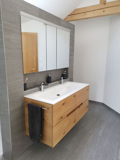 Modernes Badezimmer mit Holz-Waschtisch und Spiegel.