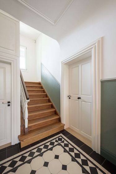 Elegante Holztreppe mit stilvollem Musterboden.