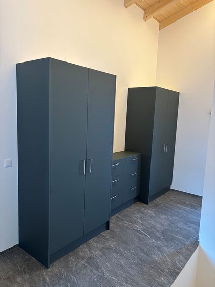 Moderne Einbauschränke in einem hellen Raum mit Akzent auf hochwertiger Holzverarbeitung.