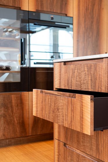 Detailaufnahme einer eleganten Küche mit Holzschränken und modernem Design.