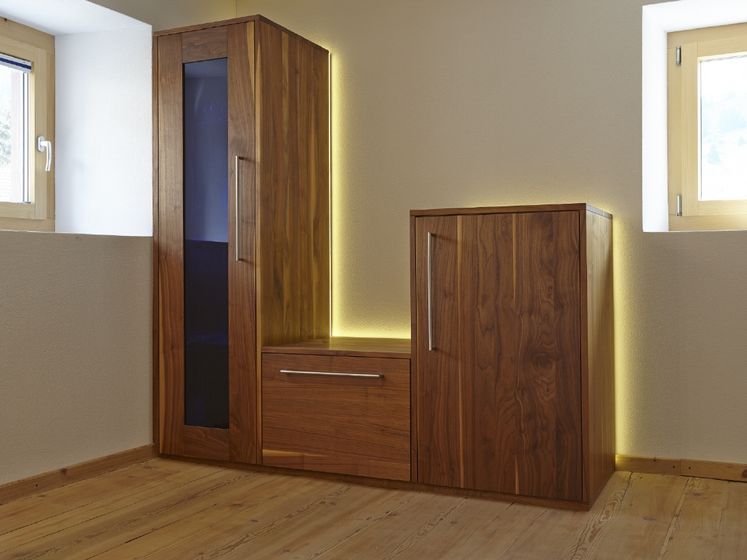 Moderner Holzschrank mit eingebauter Beleuchtung entlang der Wand.