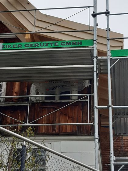 Hölzernes Gebäude mit Baugerüst an der Fassade.