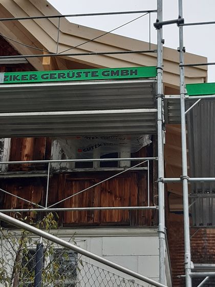 Hölzernes Gebäude mit Baugerüst an der Fassade.