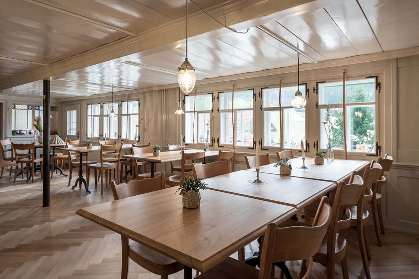 Einladender Raum mit Holzinterieur und grossen Fenstern in einem traditionellen Stil.